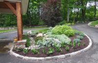 Simple foliage color and texture create this pleasing driveway planting bed in New Canaan.  Notice the use of boulders and natural river stone which provide additional textural interest.