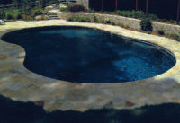 Pool in South Salem, NY with a mosaic patterned pool deck and Asher Bond stone wall.