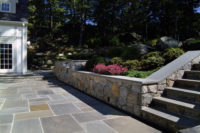 With limited space on a very steeply sloped yard, we carved out a little bit of heaven for the owners of this Scarsdale home, constructing an elegant bluestone terrace, surrounded by a fieldstone retaining wall with rock face bluestone cap and featuring a built-in grill that the owners use year-round. 