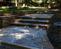 Wide and inviting, these entry steps at a home in North Stamford, CT, provide a functional, safe and attractive path. Note the flared entry to the steps that leads into the fieldstone risers and treads of the steps. Path lights illuminate the area at night for an additional element of safety. 