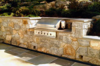 On a steeply graded site in Chappaqua, NY, we designed and built a cozy bluestone terrace with 4” patio drains and a 36” stainless steel grill nestled into the hillside retaining walls. 