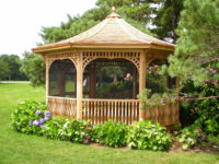 This elegant gazebo, overlooking the Long Island Sound on a Westport estate, is surrounded with lush and colorful plantings to create a feeling of privacy and solitude.