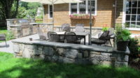In Westport, CT, we designed and built this spacious outdoor bluestone terrace surrounded by a fieldstone sitting wall. Note the 2”, rock-face, bluestone coping which makes for comfortable seating for casual get-togethers. The terrace also features a large 48” built-in grill with storage cabinet and an outdoor stainless-steel refrigerator. 