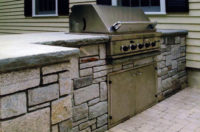 For this client in Greenwich, CT, we designed and constructed a built-in grill and storage unit utilizing pale grey granite with counters of 2”, rock-face bluestone. 