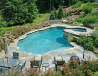 In North Stamford, in collaboration with the pool company, we constructed this natural shaped pool at the base of an extremely steeply sloped backyard. The pool fits nicely at the edge of the woodland. The masonry work, coping, pool terrace and stone slab steps enhance the naturalistic feeling. Access from the main house to the natural shaped pool at the edge of the woodland, called for our boulder and stone slab steps. The long journey to and from the pool is eased by the flights of steps and the lovely plantings. 