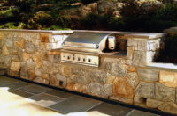 This built-in grill in Chappaqua, NY was set in a fieldstone retaining wall with weep holes at the base of the wall to allow for proper drainage from the steep hillside above it, and a 4